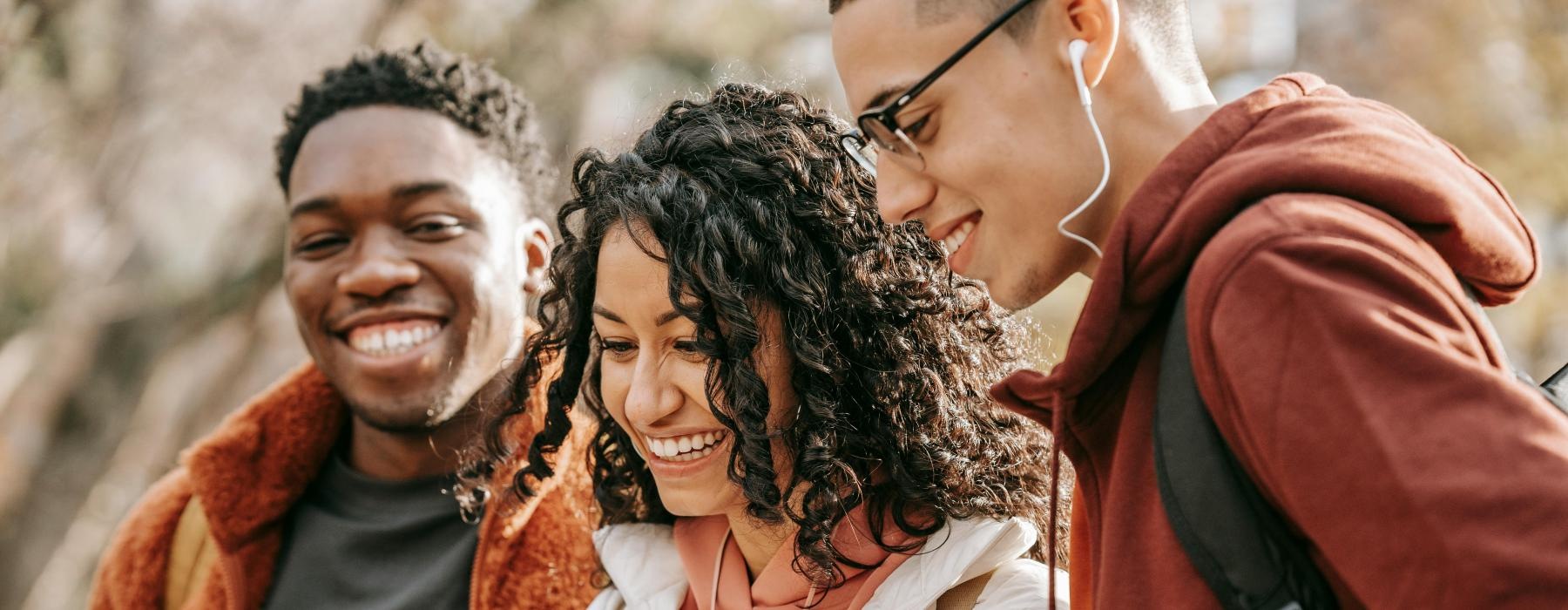 a group of people looking at a cell phone